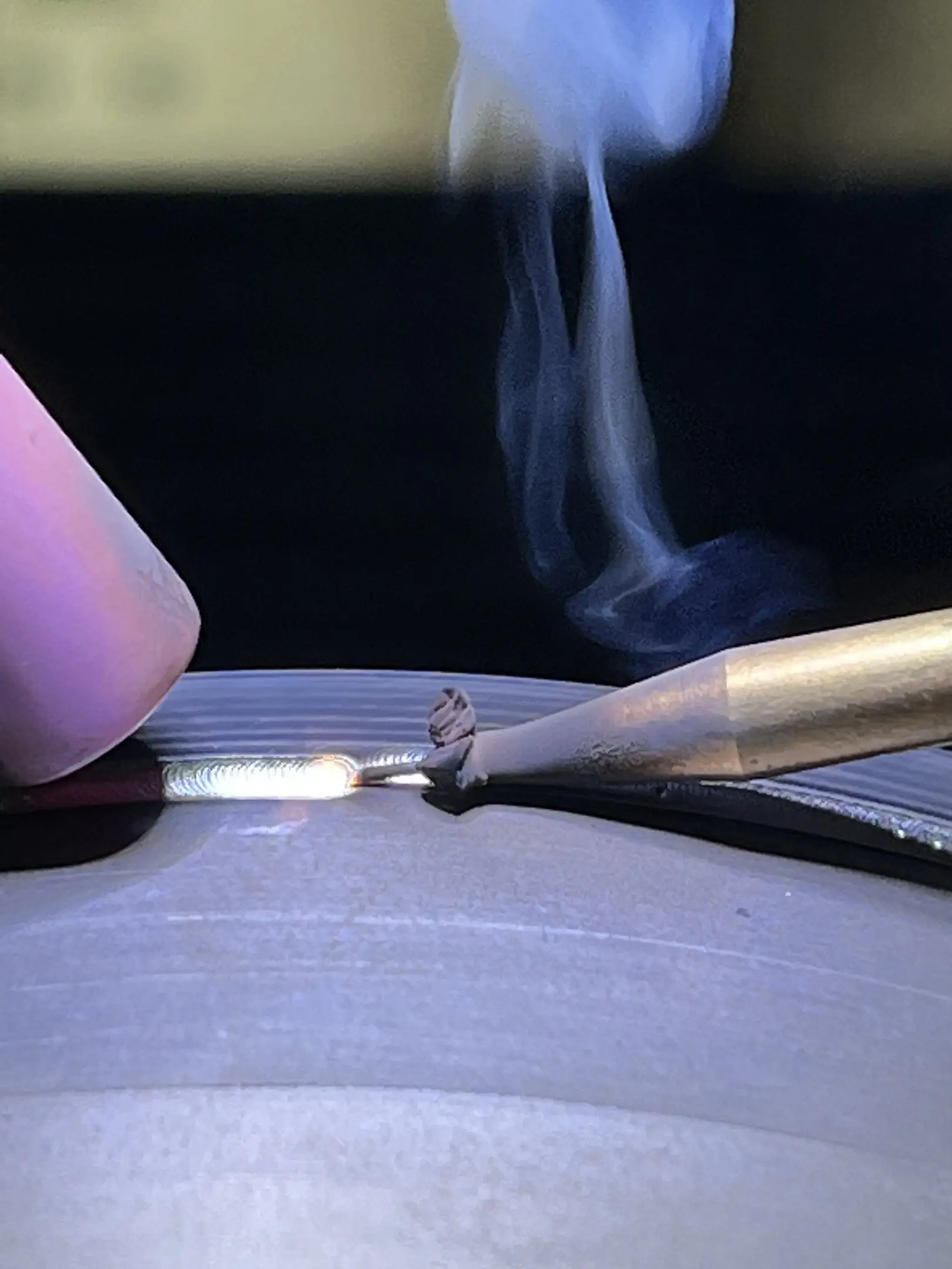 Micro-soudure laser en cours : bain de fusion incandescent, fumée et buse d'apport